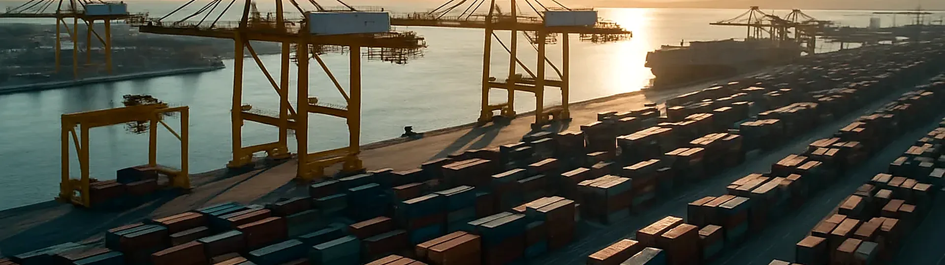 Shipping containers stacked at port representing hotel supply chain disruptions in 2022